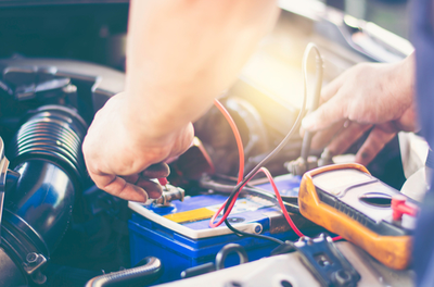 man taking battery out of vehicle