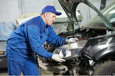 mechanic fixing a car headlight